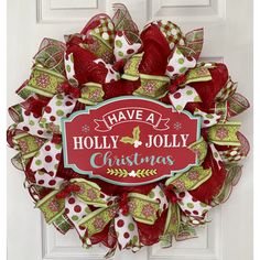 a christmas wreath on the front door with holly jollys and bow ties hanging from it