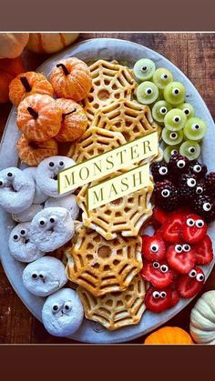 a white plate topped with lots of different types of cookies and candies covered in googly eyes