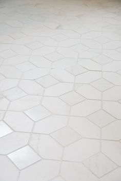 a bathroom floor with white tiles and no grouting on the top one side