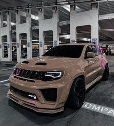 a brown jeep parked in a parking lot next to a building with graffiti on it