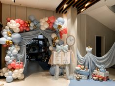 an entrance decorated with balloons and streamers for a baby's first birthday party