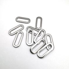 four metal paper clips sitting next to each other