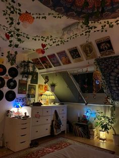 a room filled with lots of pictures and plants hanging from the ceiling over a dresser