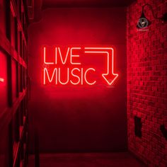 a red neon sign that says live music in the middle of a room with bookshelves