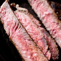 two pieces of steak sitting on top of a grill