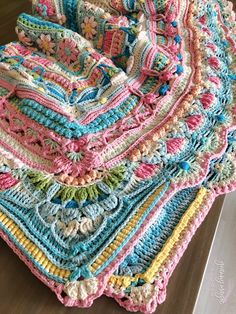 a crocheted blanket sitting on top of a wooden table