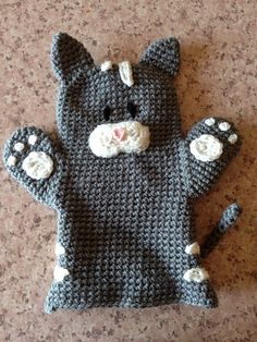 a crocheted cat is laying on the floor with it's paws out