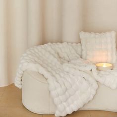 a white couch with a lit candle on it