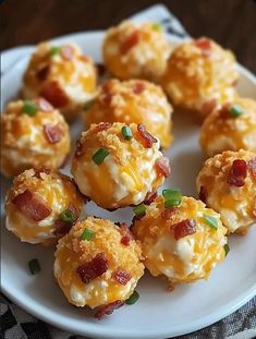 a white plate topped with mini cheeses covered in bacon and cheddar bits