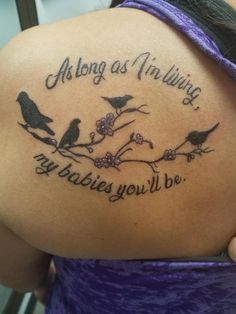 the back of a woman's shoulder with birds on it and an inscription that says, along as in living my babies you'll be