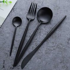 three spoons, one fork and two knives are on the table next to each other