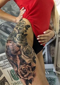 a woman's thigh with roses and a lion tattoo on her leg, next to money