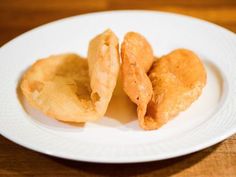 three pieces of fried food on a white plate