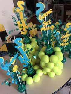 a table with tennis balls and centerpieces on it