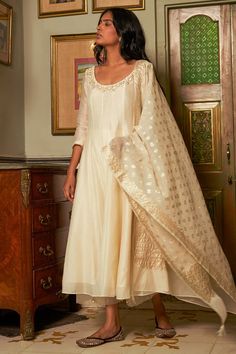 Ivory anarkali featuring sequin and pearl embroidered floral motifs on neckline. Comes with matching pant and chanderi banarasi dupatta.
Components: 3
Pattern: Embroidered
Type Of Work: Aari,Sequin,Crystal
Neckline: Round
Sleeve Type: Three quarter
Fabric: Anarkali: Chanderi,Pant: Cotton, Dupatta: Chanderi Banarasi
Color: Ivory
Other Details: 
Attached lining
Panelled anarkali
Sheer pant border
Note: Banarasi fabric will have slight variation as it is subject to availability
Occasion: Mehendi an Ivory Anarkali, Kurta Set Design, Sheer Pants, Banarasi Dupatta, Ready To Wear Saree, Indian Wedding Wear, Indian Fashion Designers, Kurta With Pants, Pernia Pop Up Shop