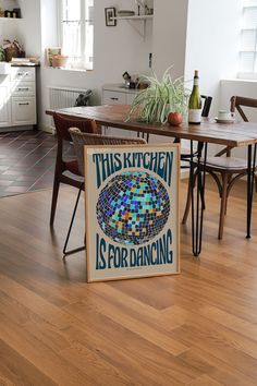 this kitchen is for dancing sign sitting on the floor in front of a dining room table