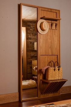 a mirror with a hat on top of it next to a bag and purses