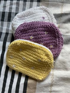 three crocheted purses sitting on top of a blanket