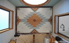 the inside of a tiny home with wood paneling on the walls and windows in it