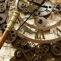 a clock made out of gears with a wooden stick sticking out of it