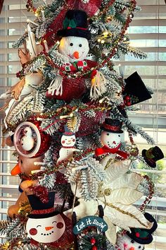 a christmas tree decorated with snowmen and other holiday decorations