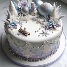 a white cake decorated with snowflakes and ornaments