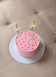 a pink birthday cake with sparklers on top