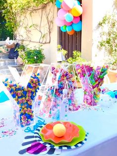 a table topped with lots of candy and balloons