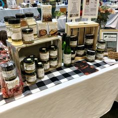 the table is covered with many different types of jams and condiments for sale