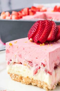 a piece of strawberry cheesecake on a plate with some strawberries in the background