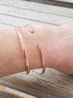 "This listing is for ONE bangle. Create your own set by choosing your size and number of bangles at checkout. Each bangle is approximately 1/8\" wide and is made from solid copper. The bangle has been embossed for texture and polished to sparkle. They are not connected, so they \"clink\" on your wrist. Each bangle is handcrafted, so slight variations will occur. NOTE: Each bangle is in its natural state. It's not coated with anything to prevent tarnish. Oils, lotions, moisture, etc. will acceler Adjustable Flexible Cuff Bracelet As Gift, Adjustable Flexible Cuff Bracelet Gift, Adjustable Stackable Bangle Bracelets, Adjustable Rose Gold Bracelets, Adjustable Bangle Cuff Bracelet, Adjustable Flexible Cuff Bangle Bracelet, Adjustable Flexible Bangle For Gifts, Adjustable Flexible Bangle Bracelet, Adjustable Stackable Rose Gold Bangle