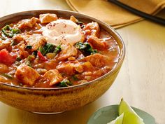 a bowl of chicken and spinach stew with sour cream on top