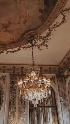 a chandelier hanging from the ceiling in a room with ornate walls and ceilings