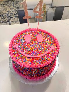 a birthday cake with sprinkles and a happy face on top