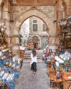 a woman is walking through an outdoor market