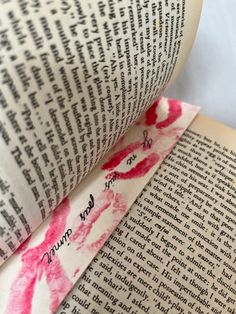 an open book with writing on the pages and pink lipstick imprints on it's cover