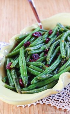 green beans with cranberry sauce in a yellow bowl on a lace doily