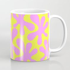 a yellow and pink coffee mug with an abstract design on the inside, sitting on a white surface