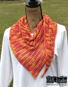 an orange and pink crocheted scarf on top of a mannequin