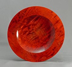 a red glass plate sitting on top of a white table