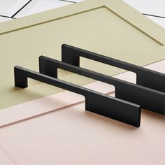 two black handles on a pink and beige table