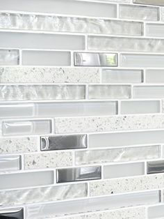 a white tile backsplash with silver accents