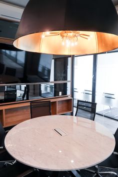 a table and chairs in a room with a large television on the wall behind it