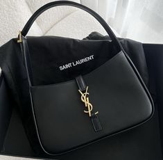 a black saint laurent bag sitting on top of a table