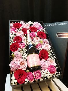 a wine bottle in a box with flowers