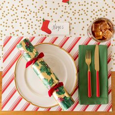 a place setting with napkins, silverware and christmas wrapping