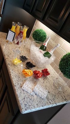 a kitchen counter topped with lots of fruit and drinks