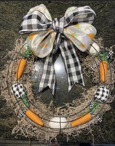 a decorated wreath with carrots and an easter egg on the front door hanger