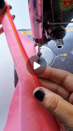 someone is using a sewing machine to sew the fabric on their pink dress shirt