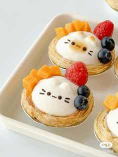 four desserts with fruits and cheese on them are arranged in the shape of hello kitty